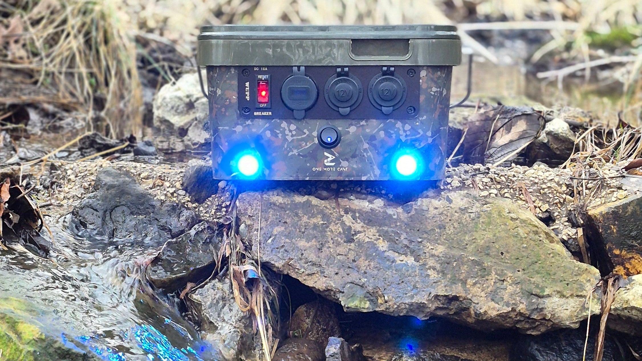 Small electronic device with blue lights on a rocky stream